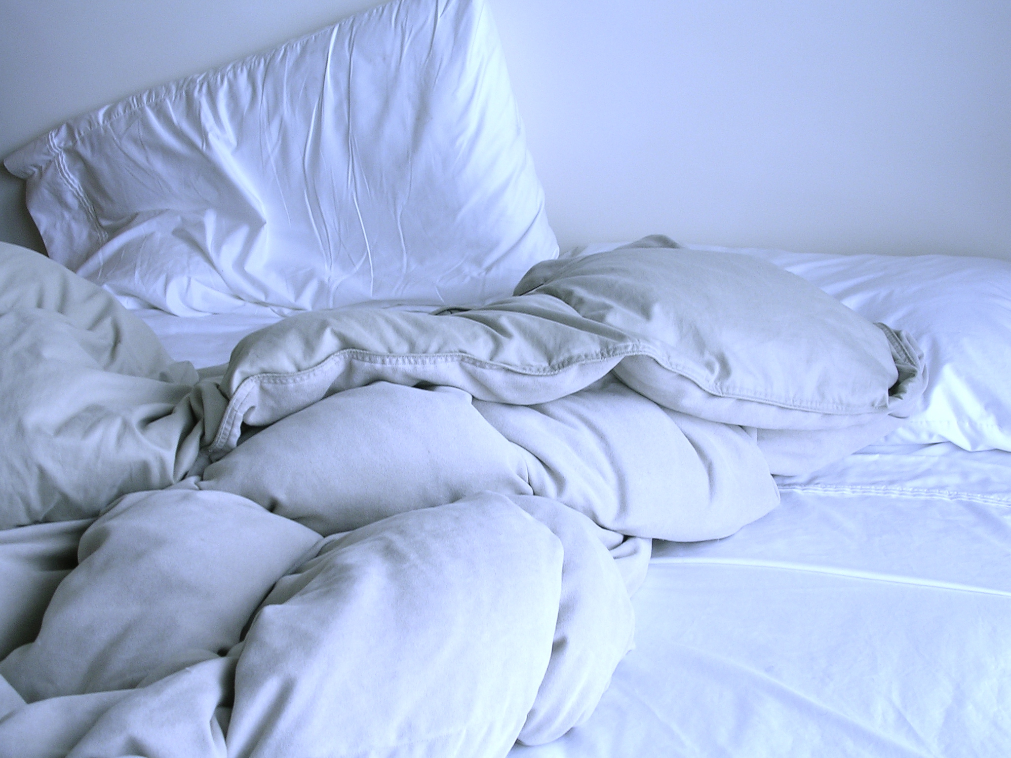 Разобранная постель. Смятая постель. Смятая кровать. Незастеленная кровать. Скомканное одеяло.